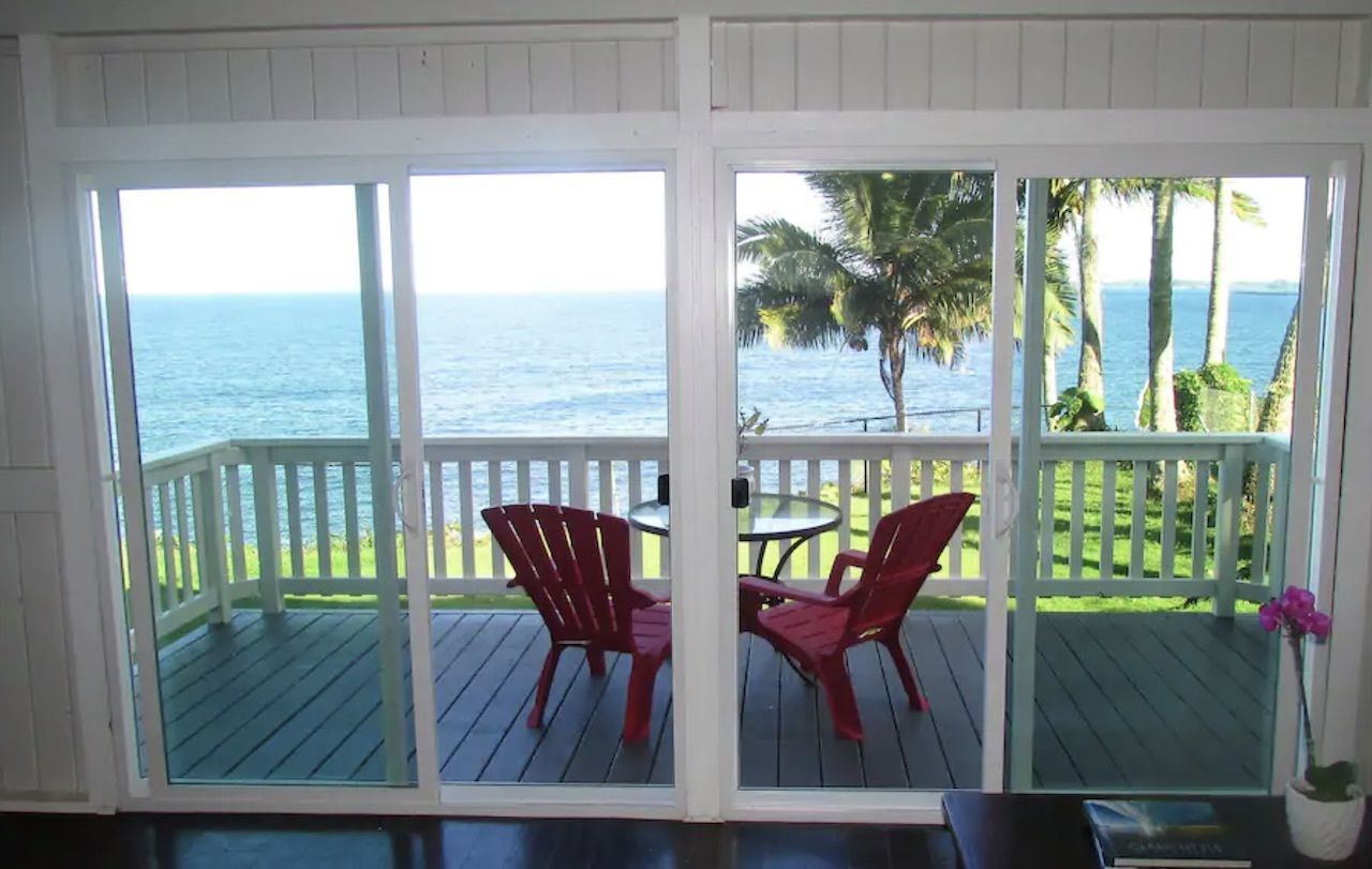 patio area with two red chairs Hilo Hale Kai at Honolii Oceanfront, best airbnbs on the big island 
